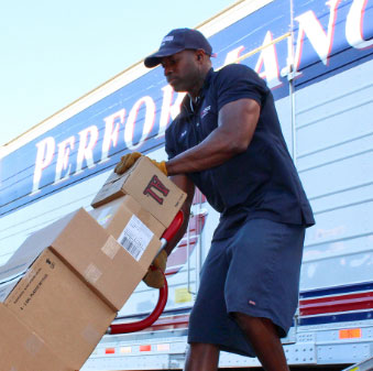 Delivery Person Pushing Boxes on a Trolley 